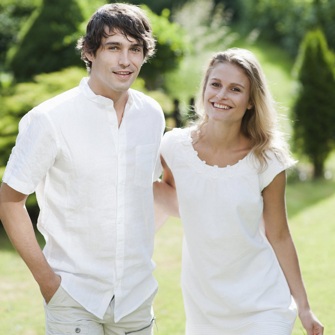 Man and woman standing together in a park with greenery in the background